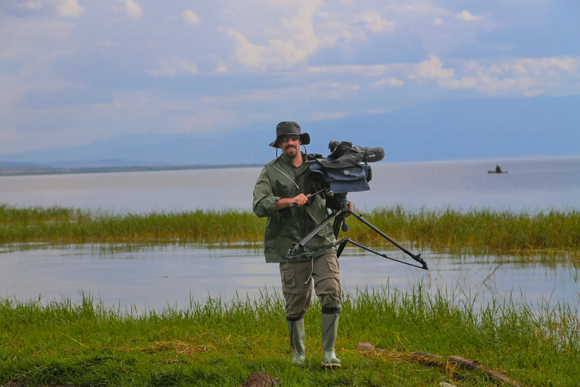 Director of photography with a camera on a tripod by a lakeshore
