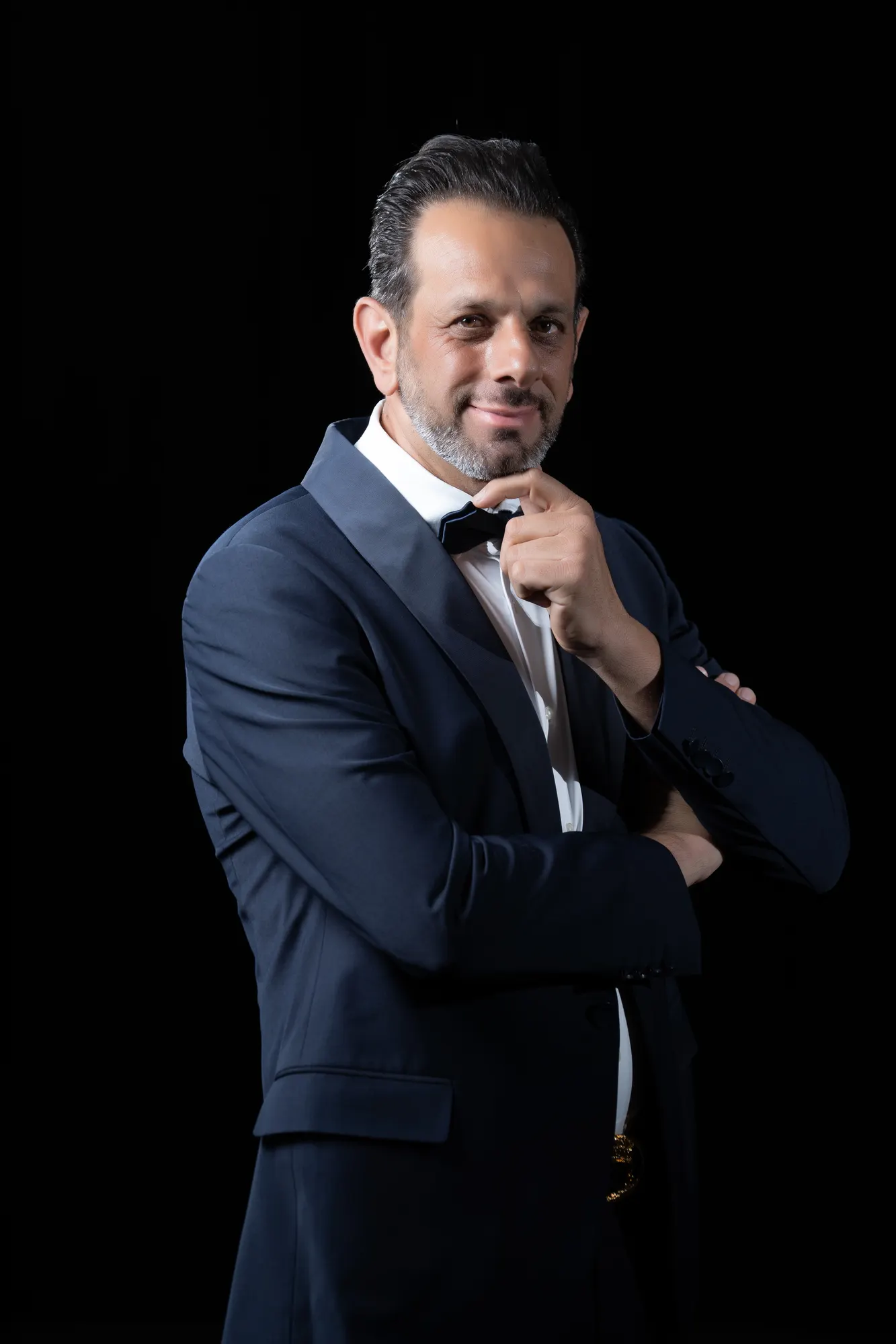 Confident man in a suit and bow tie, low-key studio portrait