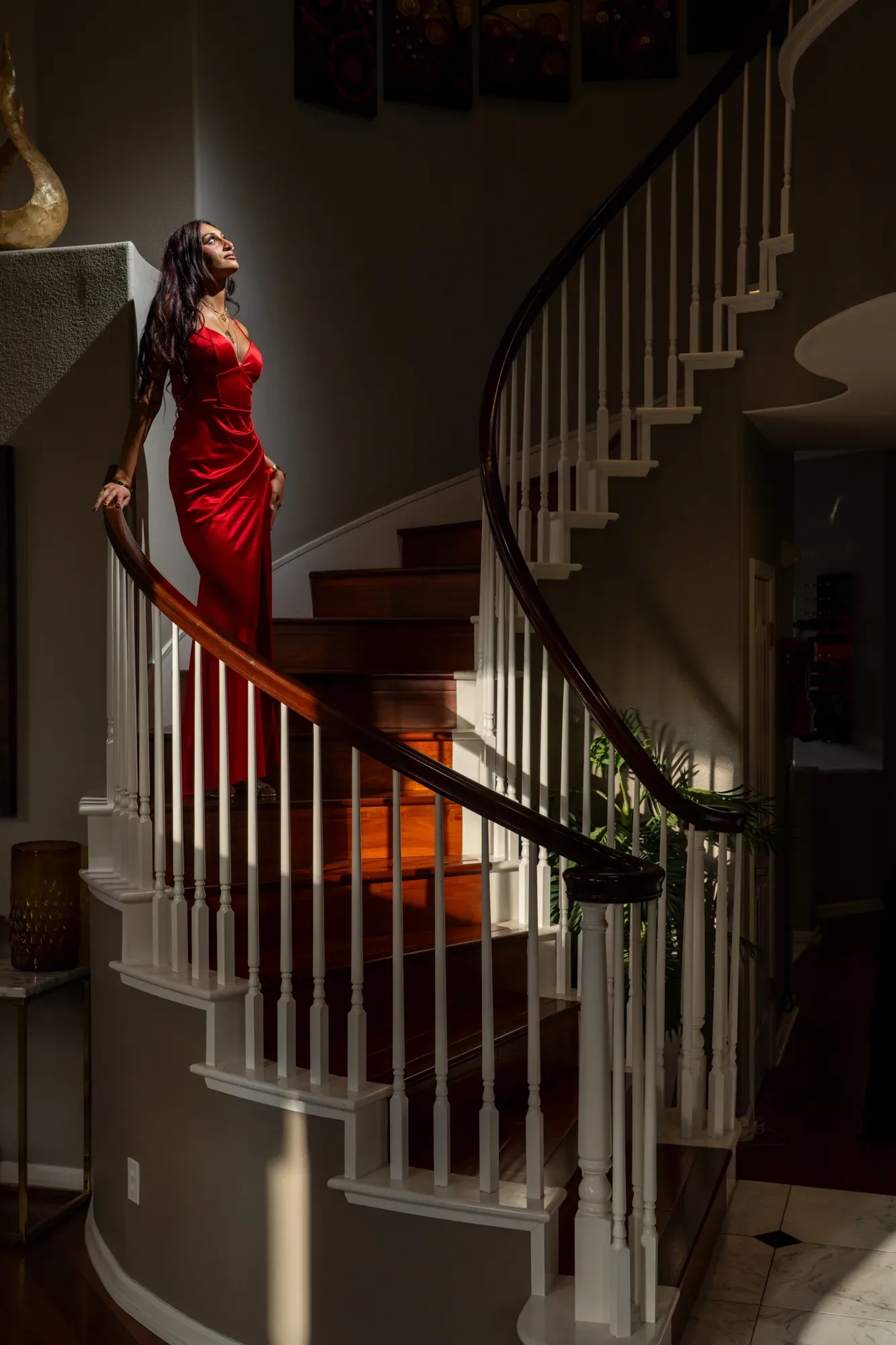 Woman in a red gown on a spiral staircase, portrait session