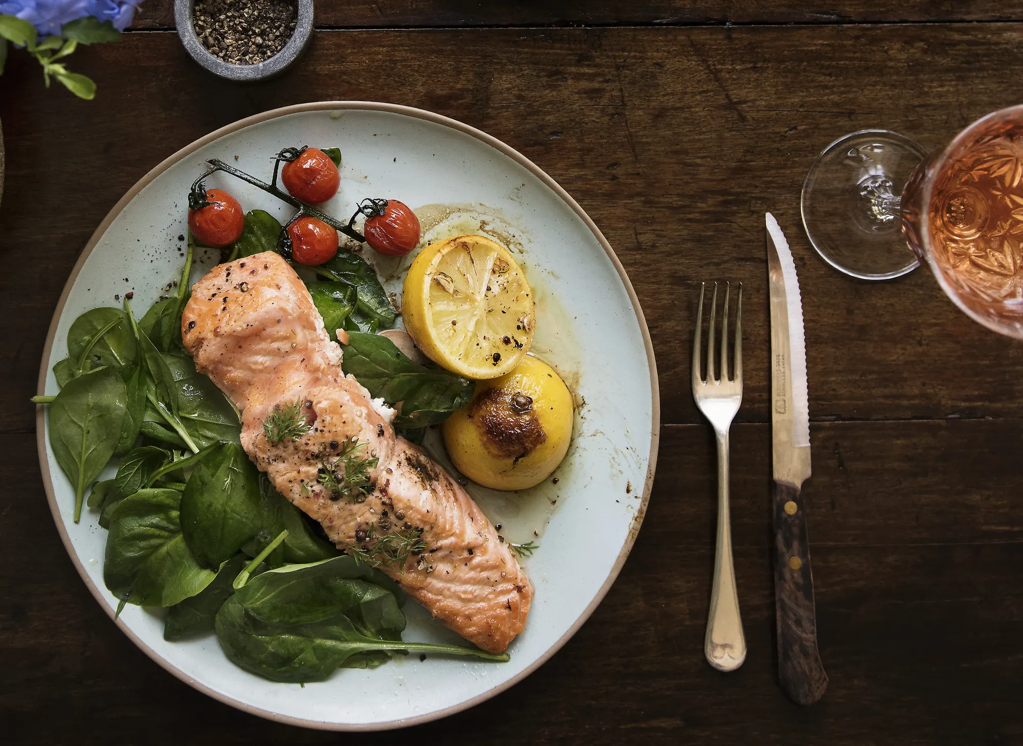 Grilled salmon fillet with spinach, lemon and cherry tomatoes, menu photography