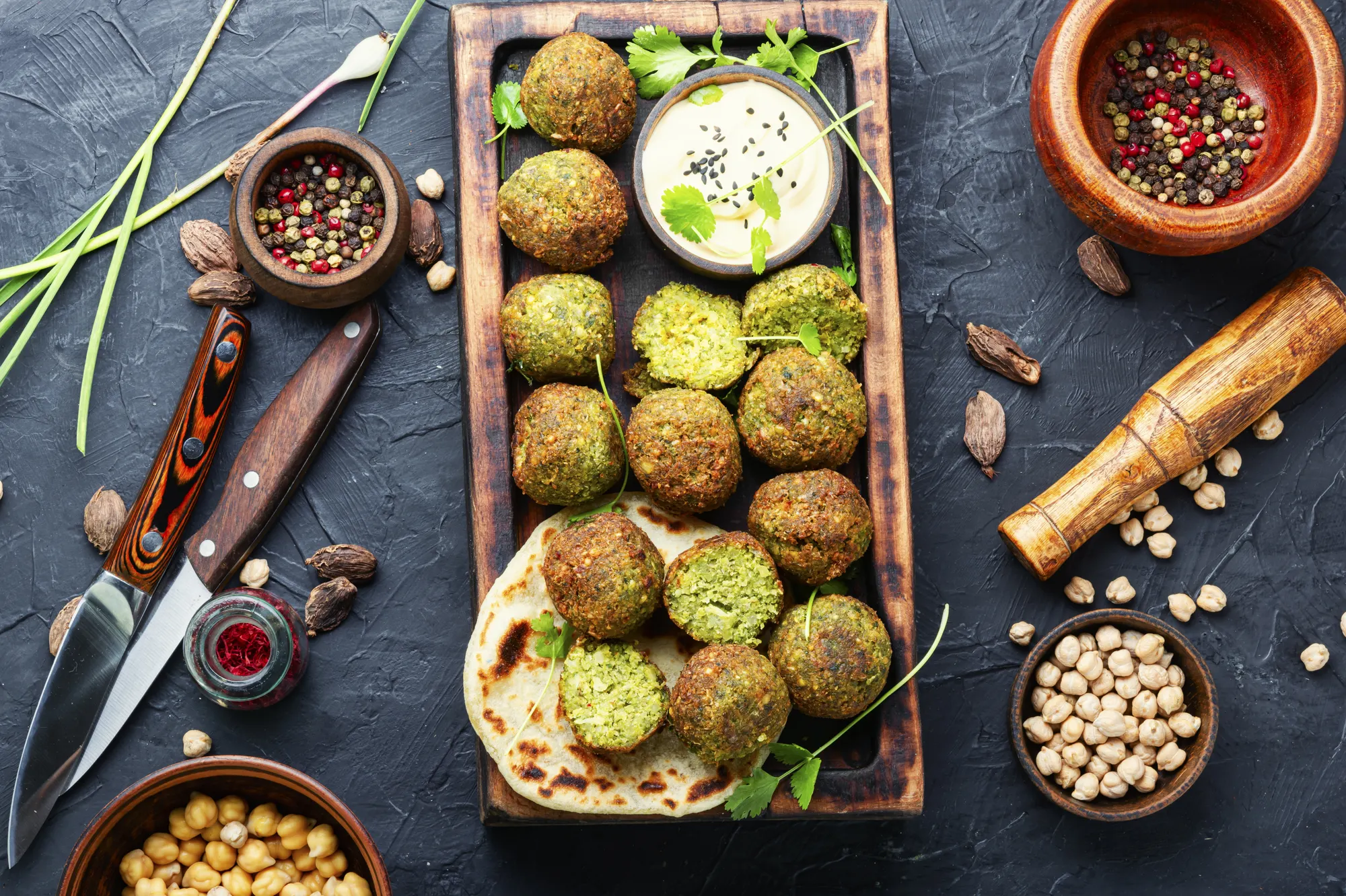 Falafel platter with tahini, chickpeas and spices, overhead food photo