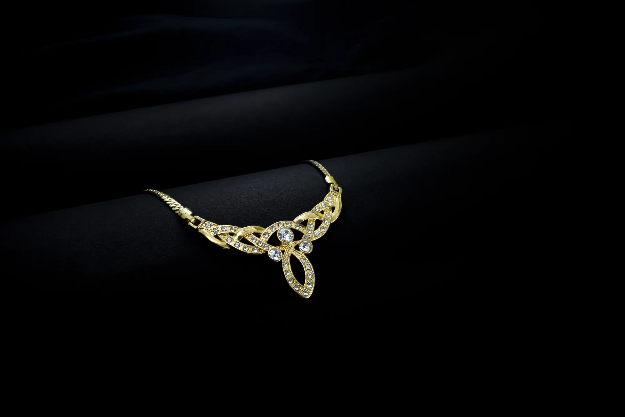 Gold necklace on a black background, jewelry product photography