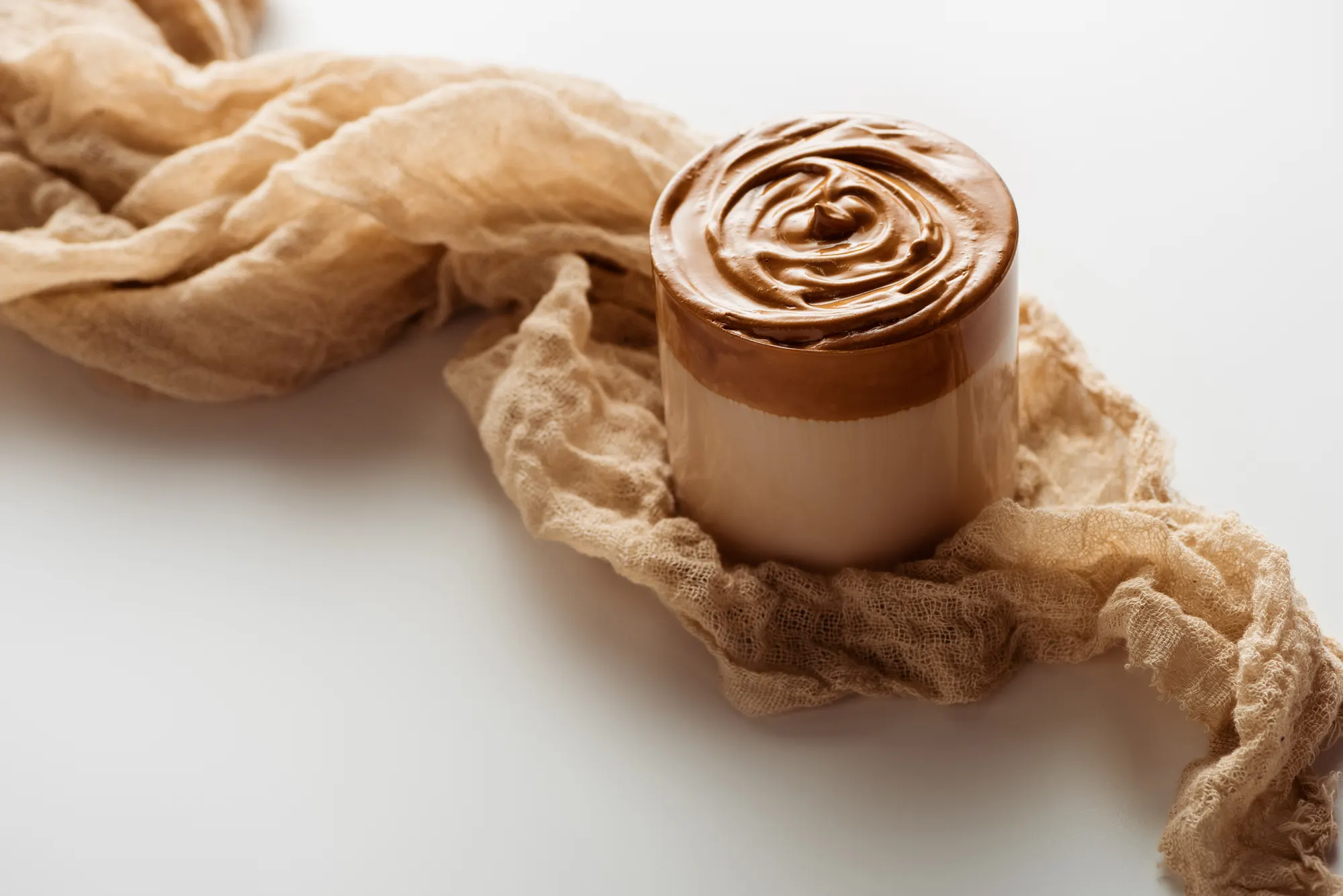 Whipped coffee jar on linen, lifestyle product shot